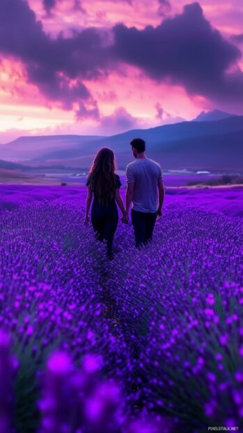 Love Wallpaper with a couple walking through a field of lavender flowers at dusk, holding hands and gazing lovingly into each others eyes.