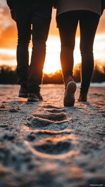 Love iPhone Wallpaper with a couples footprints in the sand leading toward the horizon, symbolizing a journey of love and togetherness.