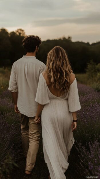 Nature Love Wallpaper with a couple walking through a field of lavender flowers at dusk, holding hands and gazing lovingly into each other eyes.