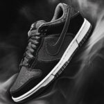 Nike Dunk sneakers in a stylish monochrome color scheme, highlighted on a dark, textured background with soft lighting effects.