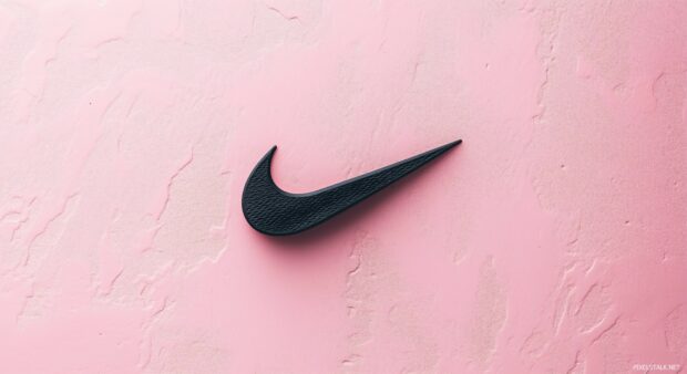 Nike logo in black on a soft pastel pink background.