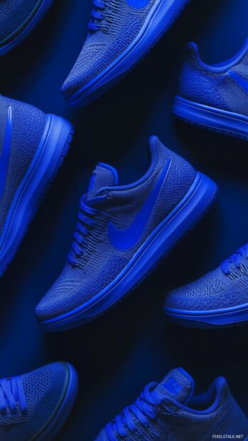 Nike sneakers in various shades of blue, arranged artistically against a deep blue backdrop.