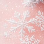 Soft pink Christmas Wallpaper with delicate white snowflakes and stars.