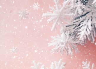 Soft pink Christmas Wallpaper with delicate white snowflakes and stars.