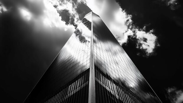 The Freedom Tower standing tall with the reflection of clouds in its glass.