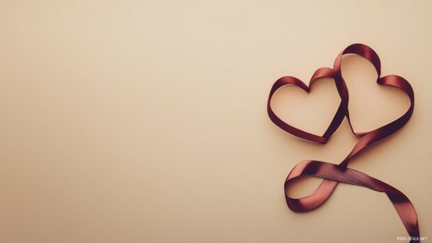 Two intertwined hearts made of red silk ribbons on a light beige background.