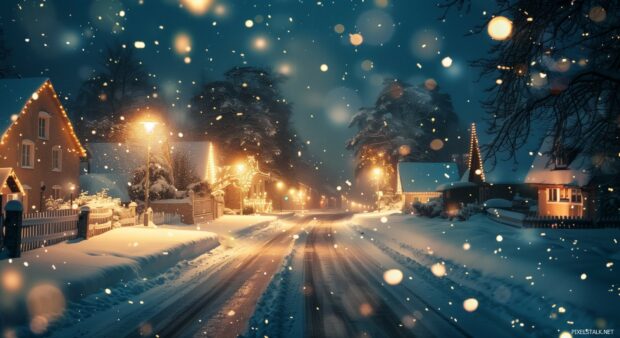 Winter village illuminated by warm street lights and falling snow.